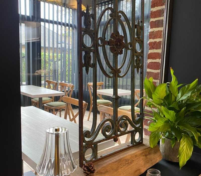 Zonovergoten eettafel met elegante tafelschikking en frisse bloemen bij La Bonne Vie.